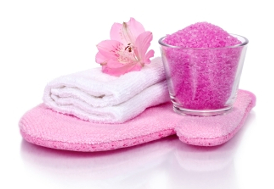pink bathroom composition with scrubbing glove, bath salt, towel and flower (with reflexion)